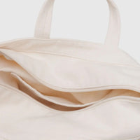 Close-up of a beige Baggu horizontal zip duck bag showing inner pocket detail with a plain background