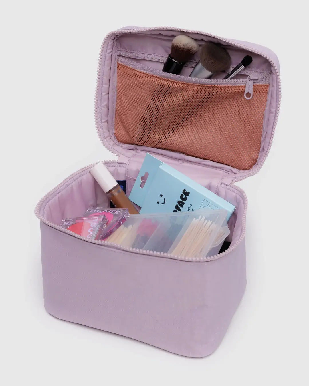 Pale pink Baggu cosmetic case makeup open showing interior and cosmetic items on a light gray background