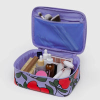 apple tree printed small baggu cosmetic case shown opened with a nail brush, rose quartz gua sha and a variety of other toiletries and cosmetics inside