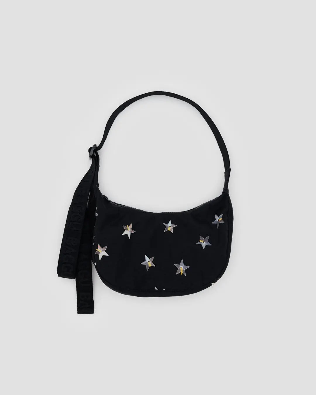 Black Baggu small crescent bag with silver star print that look like large sequins on a light gray background