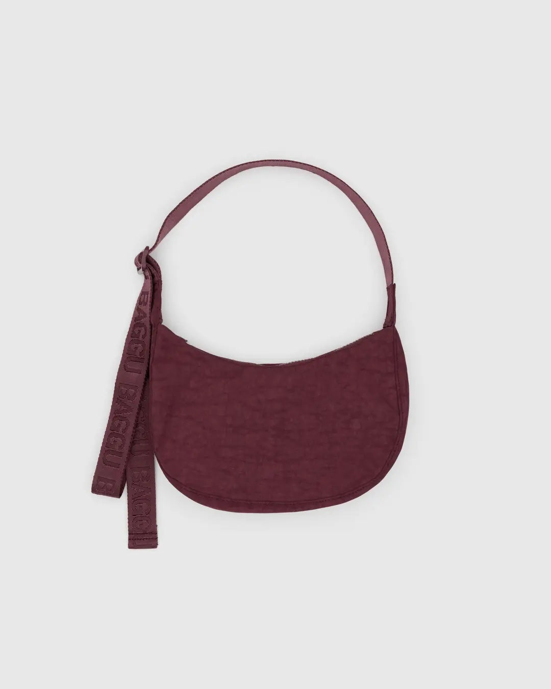 baggu small nylon crescent bag in mahogany red against a pale grey background