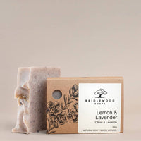 Bar of soap with a cardboard box labeled 'Bridlewood Natural Soaps Lemon & Lavender' on a beige background