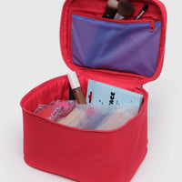 an open view of a candy apple red baggu cosmetic case showing interior pocket and a variety of cosmetics