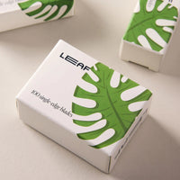 Box of 100 LEAF single-edge blades with green leaf design on a light surface