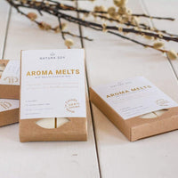 Natura Soy Aroma Melts packaging on a light background with branches.