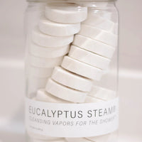 Jar of eucalyptus steam tablets with a white label on a light background