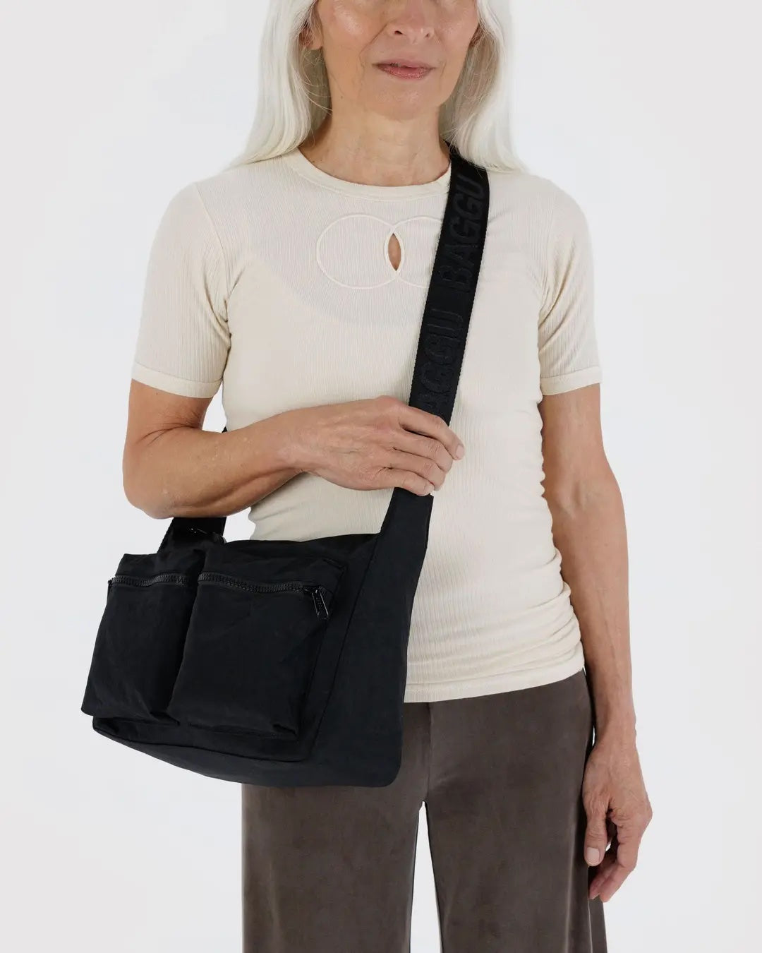 Person wearing a black baggu cargo crossbody bag on a white background