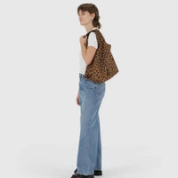 a person carrying a leopard print standard baggu on their shoulder