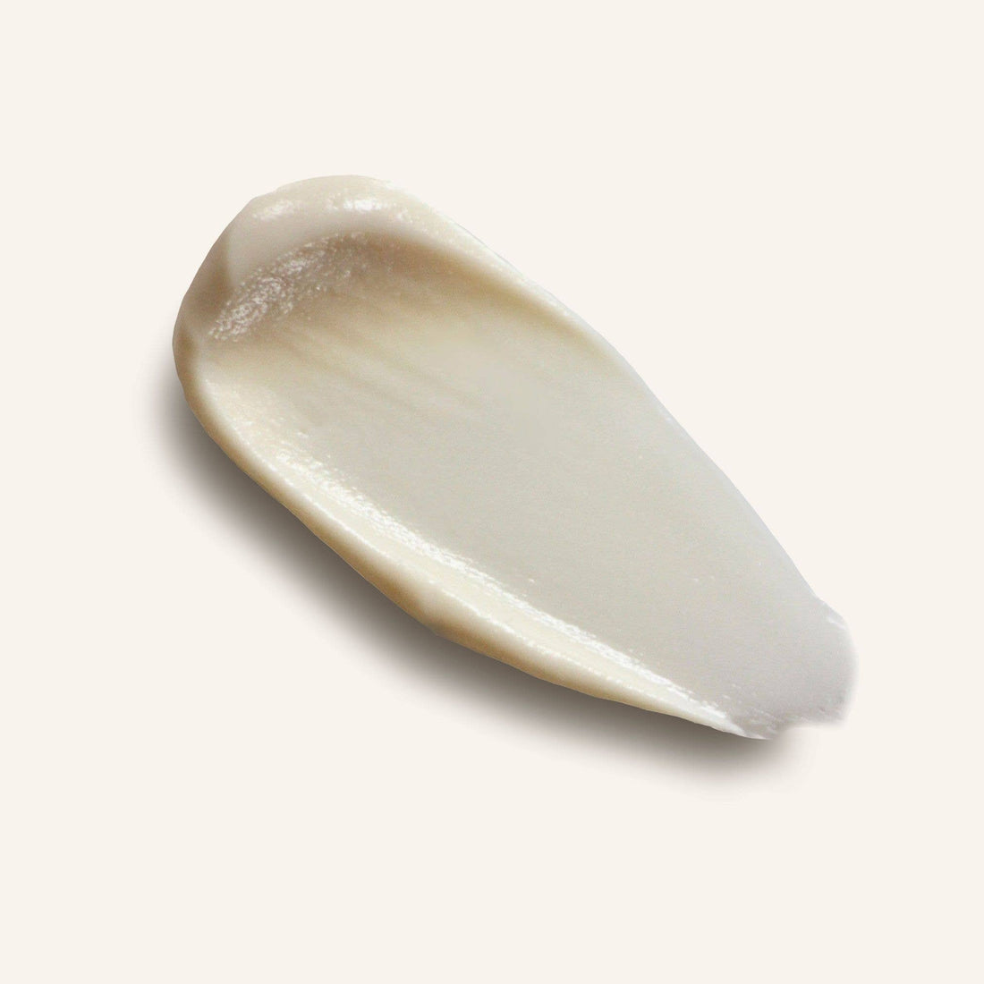 Close-up of Routine's Cat Lady deodorant cream smeared on a light gray background to show the rich creamy texture of the product