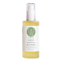A clear pump bottle with a yellow gel cleanser labeled WASH 'Brightening Gel Cleanser' by Wildcraft. The bottle is shown against a white background.