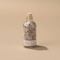 a bottle of well kept soaking salts on a beige background