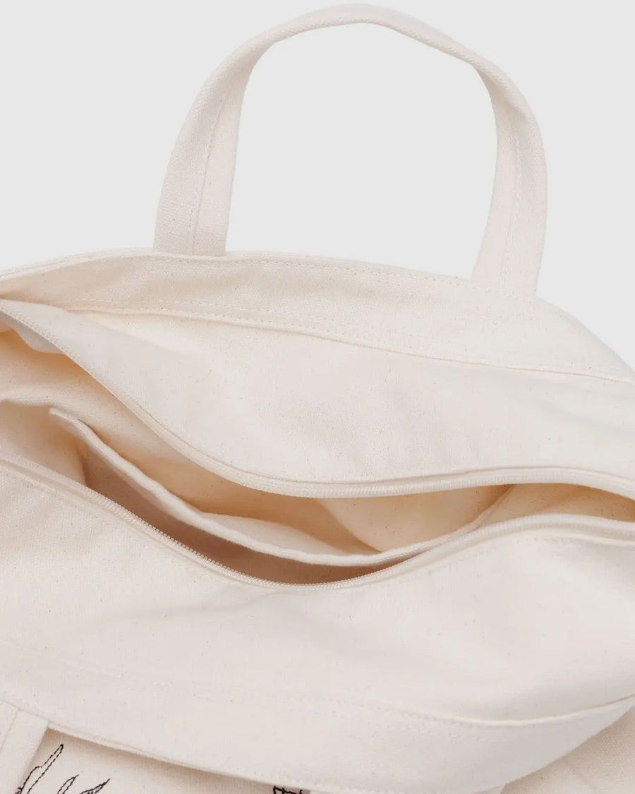 Close-up of a beige Baggu horizontal zip duck bag showing inner pocket detail with a plain background