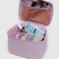 Pale pink Baggu cosmetic case makeup open showing interior and cosmetic items on a light gray background
