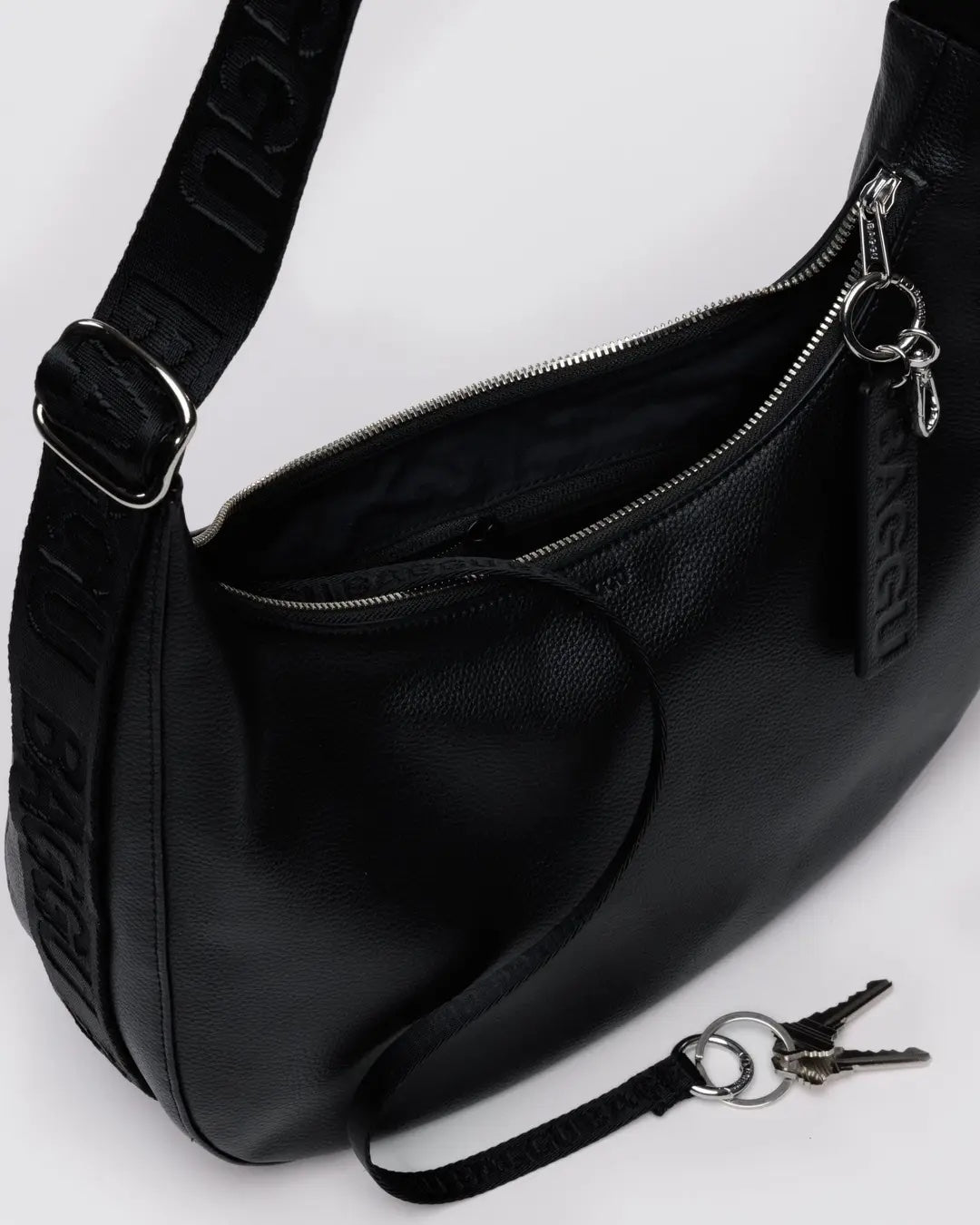 Black leather Baggu medium crescent bag close up showing keychain and other high quality finishing details