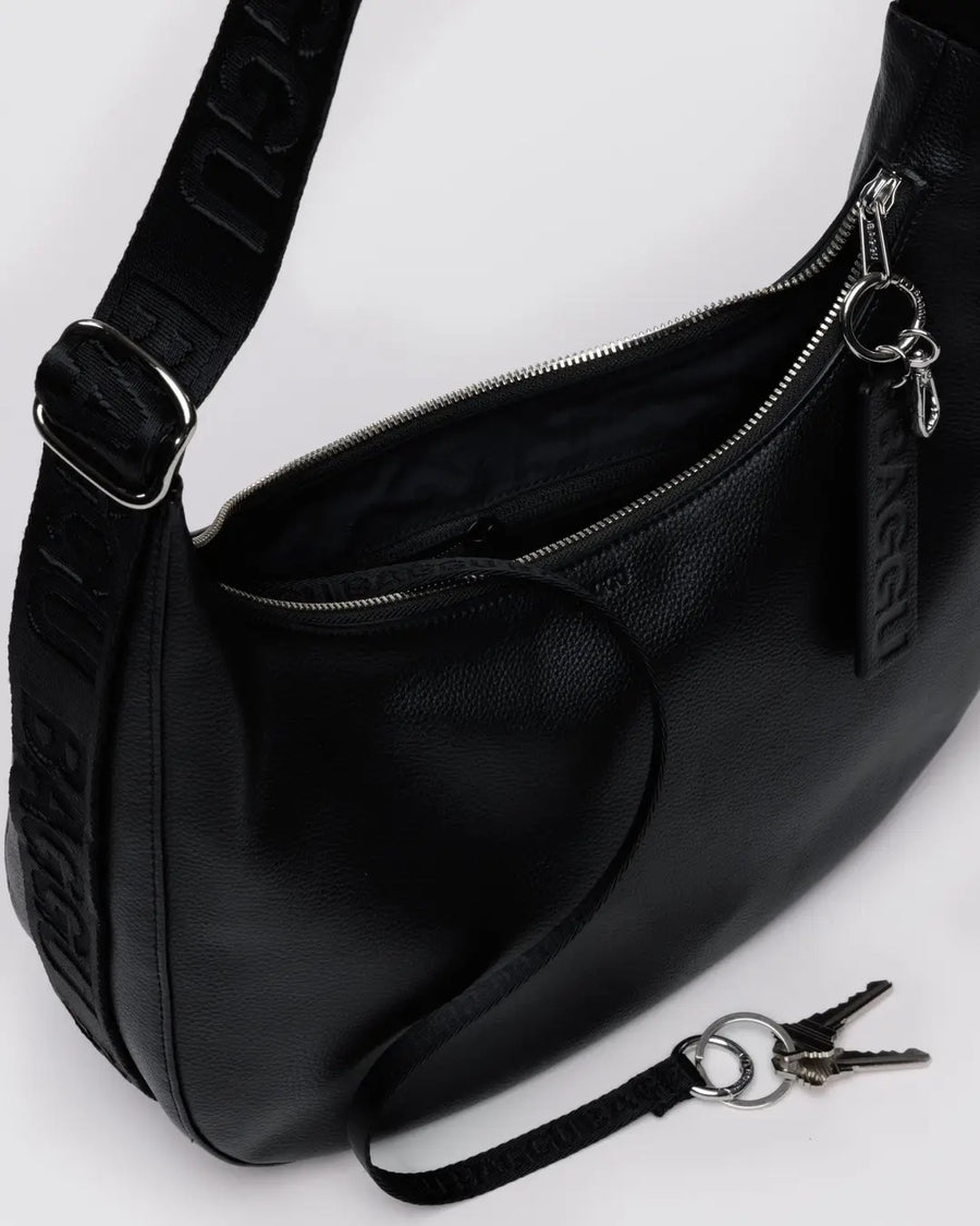 Black leather Baggu medium crescent bag close up showing keychain and other high quality finishing details