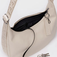 Stone Baggu leather medium crescent bag with open top showing black interior, keychain, and visible branding details