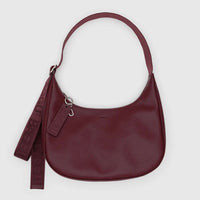 baggu medium crescent bag in mahogany made from recycled leather with matching strap and embossed key lanyard detail against a white background