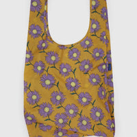 Reusable Big Baggu bag with purple floral pattern on a mustard yellow background