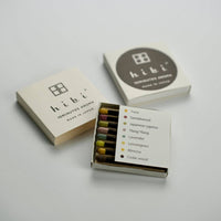 Matchbox containing 8 different hibi 10 minute aroma incense matches with 'hibi' branding on a light gray background