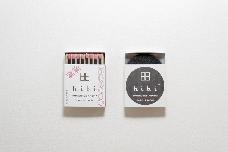 Two packages of hibi sandalwood incense matches on a white background