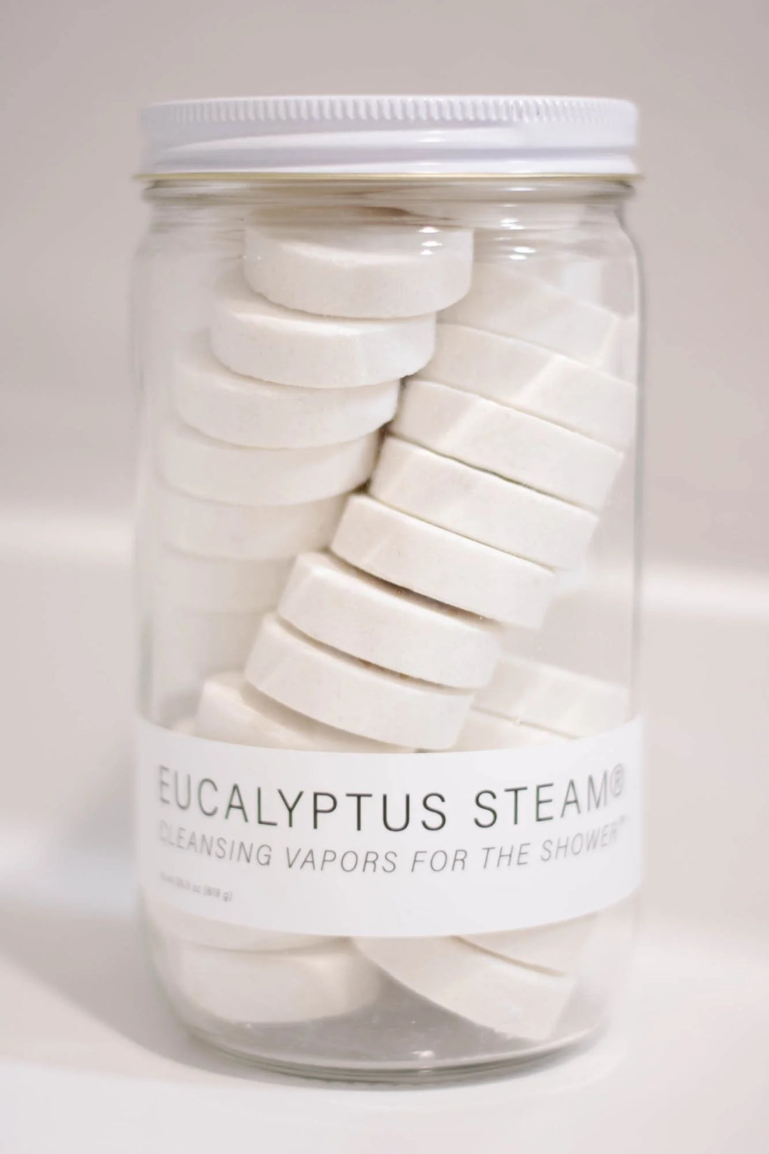 Jar of eucalyptus steam tablets with a white label on a light background