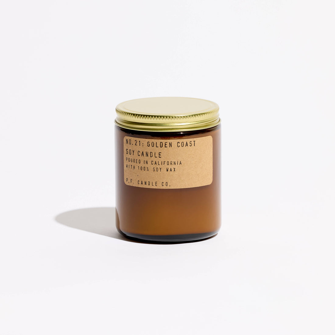 p.f. candle goldcoast scented candle with a gold lid and label on a white background