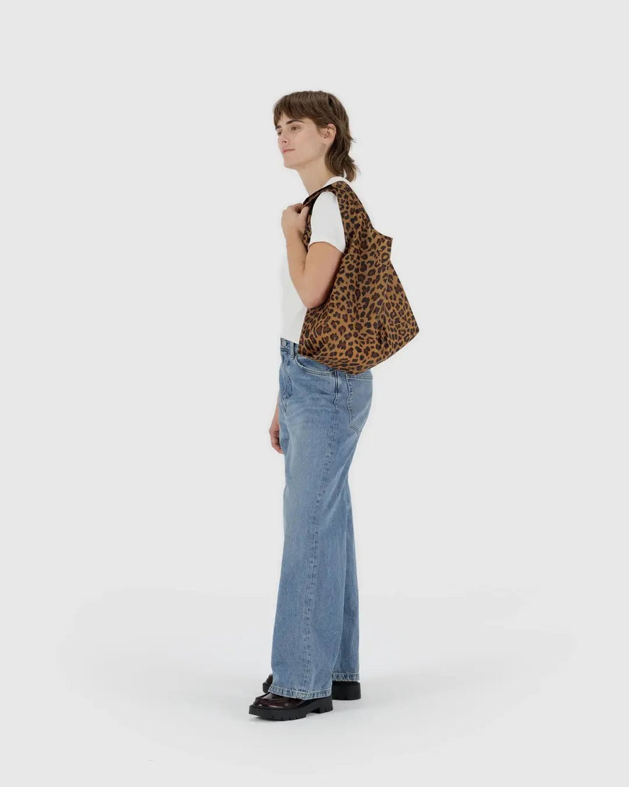 a person carrying a leopard print standard baggu on their shoulder