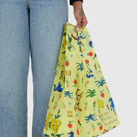 a person from the waist down is shown holding a painted prairie standard baggu reusable bag