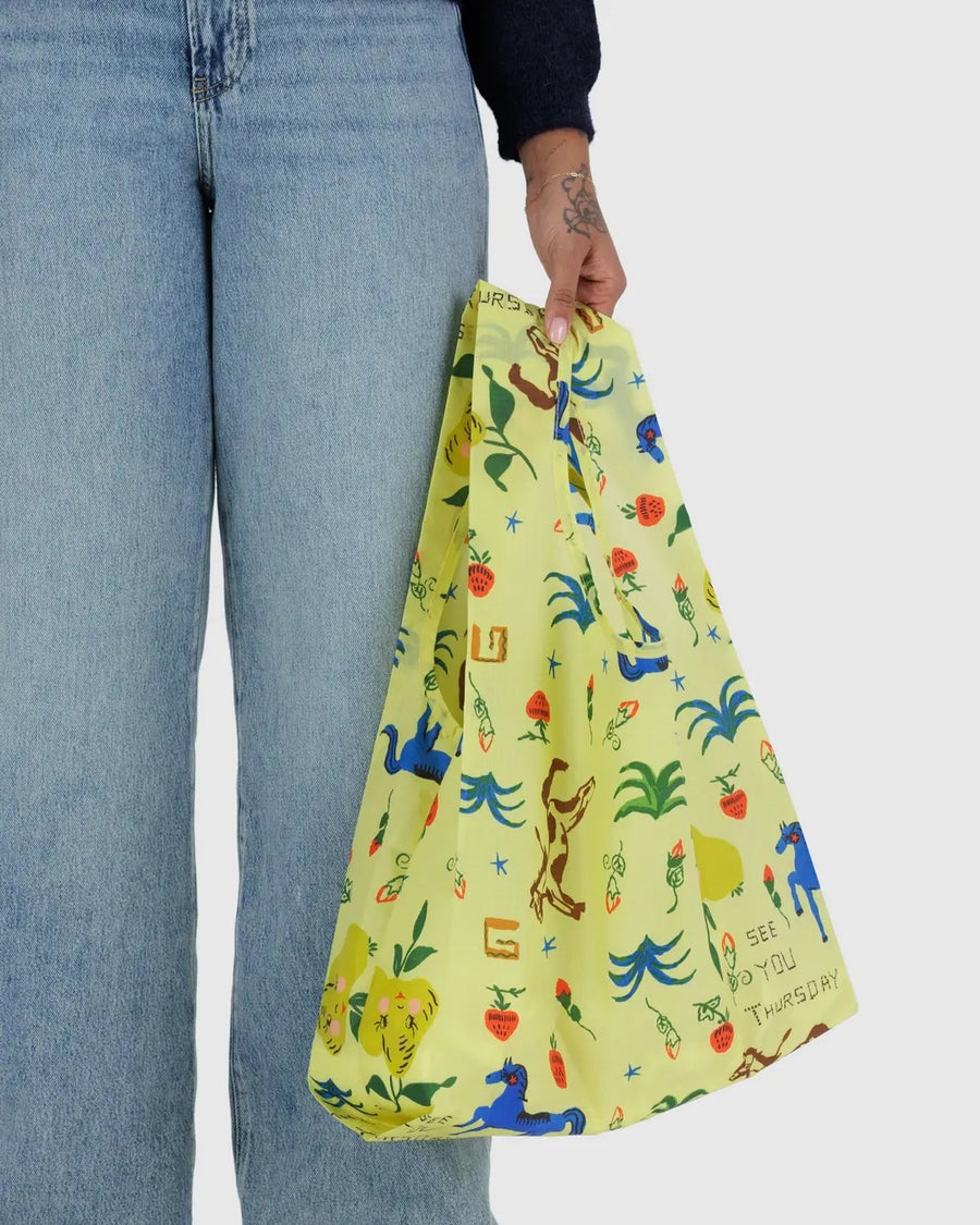 a person from the waist down is shown holding a painted prairie standard baggu reusable bag
