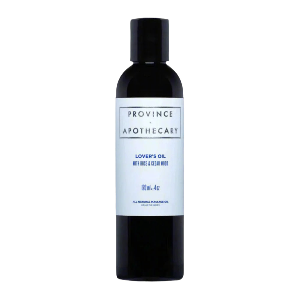 a dark bottle with pale blue label that says "Province Apothecary Lover's Oil with Rose & Cedar wood". The bottle is filled with the clear liquid massage oil blend.