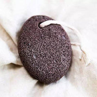 Black pumice stone on a white fabric background