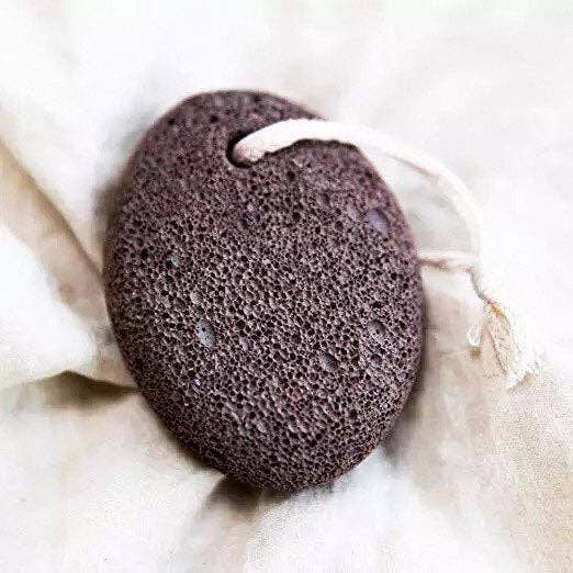 Black pumice stone on a white fabric background