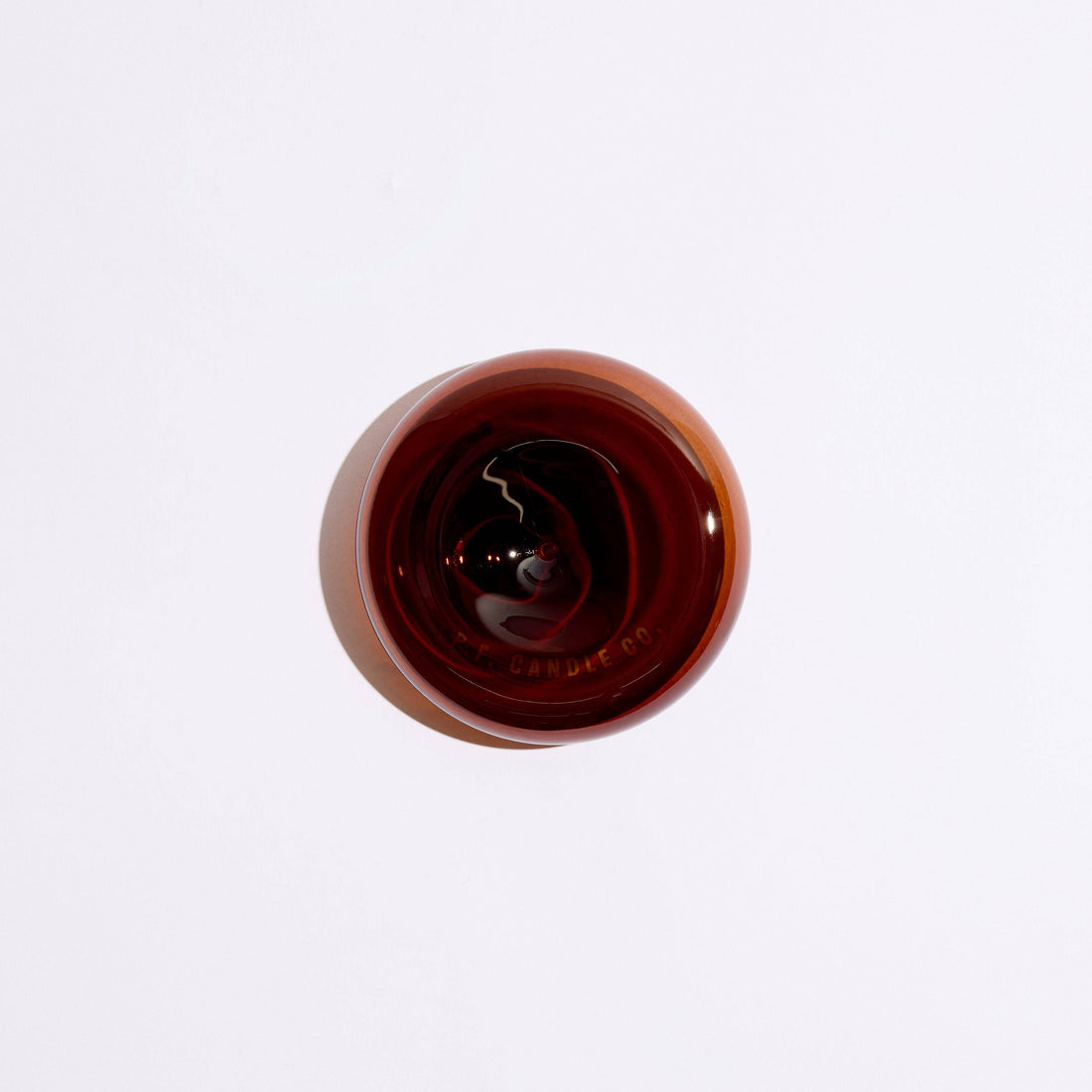 round amber glass incense holder top down view on a white background  