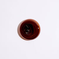 round amber glass incense holder top down view on a white background  