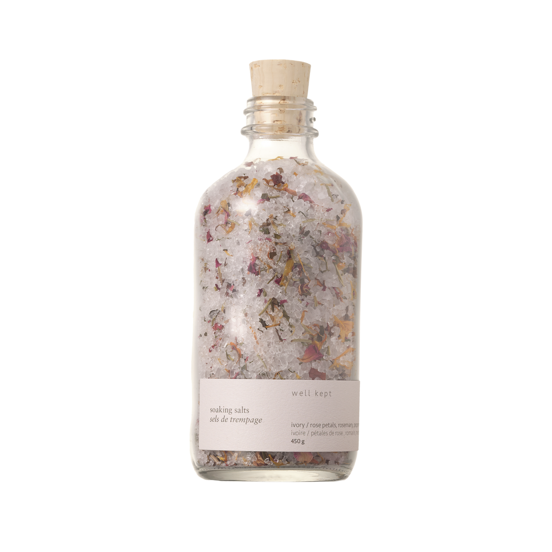 A clear glass bottle with a cork stopper, labeled 'Soaking Salts - Thrive' by Well Kept.