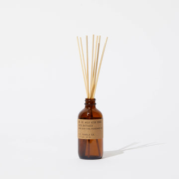 P.F. Candle Wild Herb Tonic reed diffuser in amber glass diffuser bottle with wooden sticks on a white background