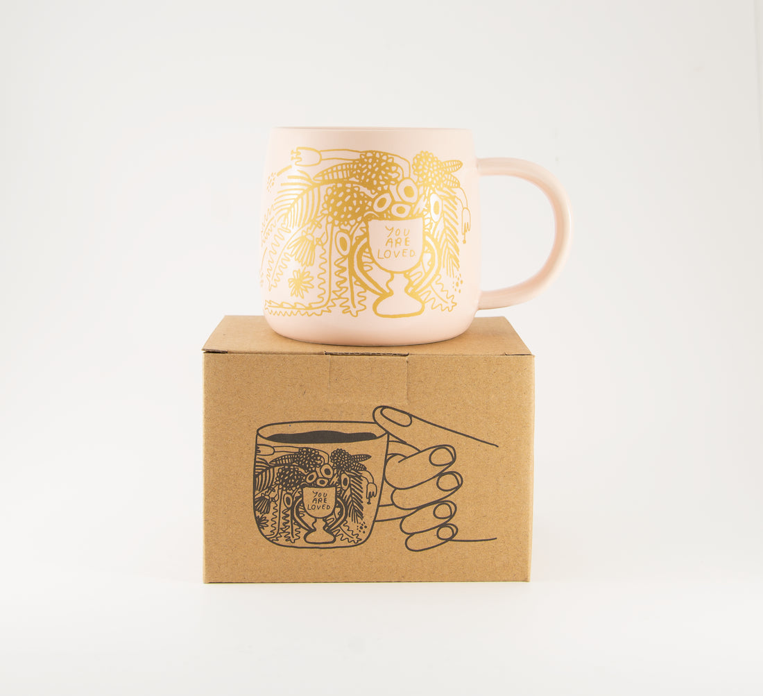 ceramic mug with text "you are loved"