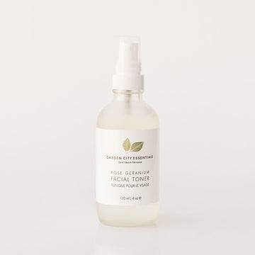 A white spray bottle containing Garden City Essentials Rose Geranium Facial Toner, designed for use as a refreshing facial mist.