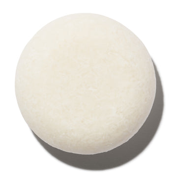 A round, white unscented 'Aspen' shampoo bar by Notice Hair Co against a white background.
