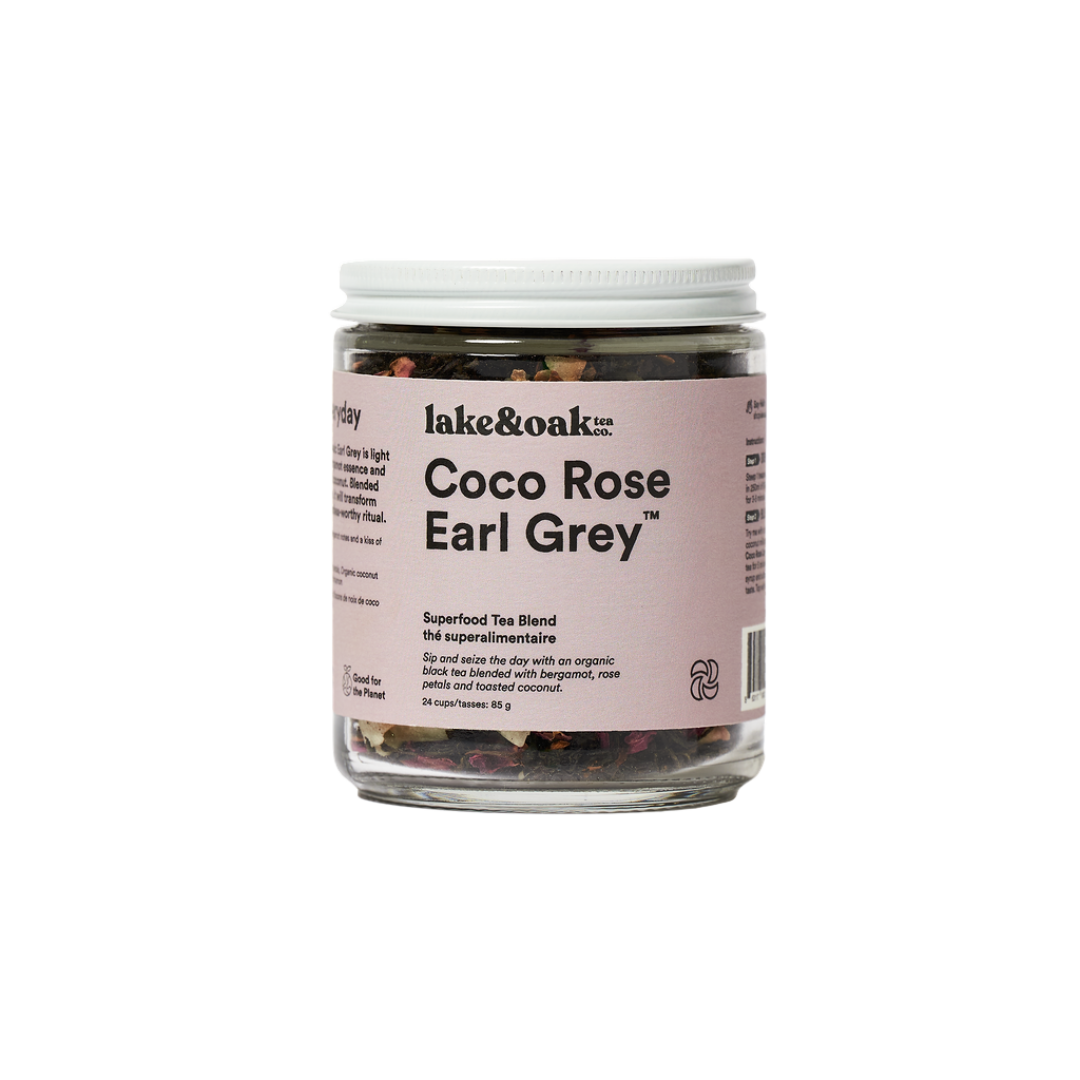 A jar of Coco Rose Earl Grey superfood tea blend by lake&oak. The jar is labeled with the product name and contains visible pieces of rose petals, coconut flakes, and other tea leaves.