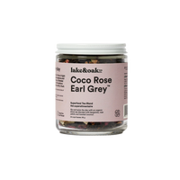 A jar of Coco Rose Earl Grey superfood tea blend by lake&oak. The jar is labeled with the product name and contains visible pieces of rose petals, coconut flakes, and other tea leaves.