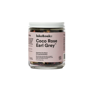 A jar of Coco Rose Earl Grey superfood tea blend by lake&oak. The jar is labeled with the product name and contains visible pieces of rose petals, coconut flakes, and other tea leaves.