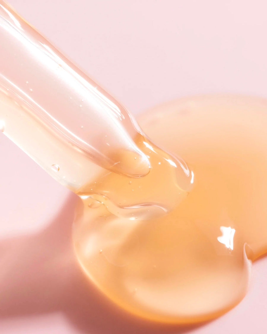 a close-up image of a pipette dispensing Three Ships Jelly Drops Kaduku Plum + Mushroom Hyaluronic serum onto a pale pink surface to show the jelly-like texture of the product